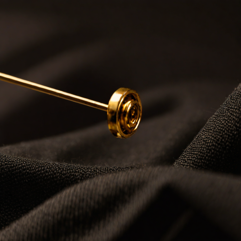 Gold tailor's pin on charcoal fabric